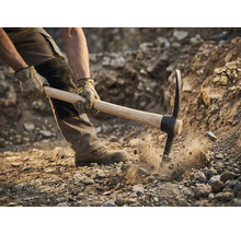 Un homme utilise une pioche pour creuser dans le sol
