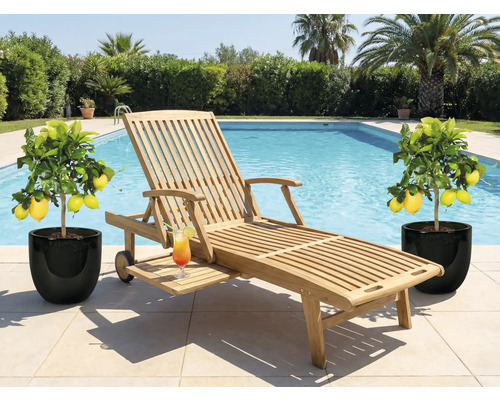 Chaise longue en bois avec cocktail et citronniers au bord de la piscine