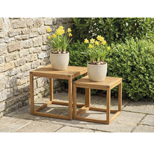 Deux tables d'appoint carrées en bois avec des jonquilles en pot dans le jardin