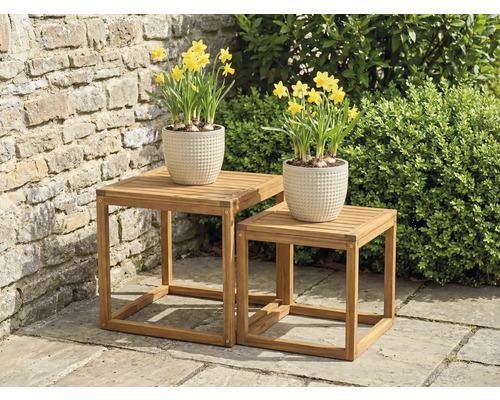 Deux tables d'appoint carrées en bois avec des jonquilles en pot dans le jardin