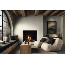 Gemütliches Wohnzimmer mit brennendem Kamin, zwei Teddy-Sesseln, Couchtisch aus Massivholz und Deckenbalken aus Holz im modernen Landhausstil.