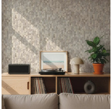 Mur avec papier peint à motif géométrique beige et gris derrière un buffet en bois avec tourne-disque et plante dans un salon lumineux.