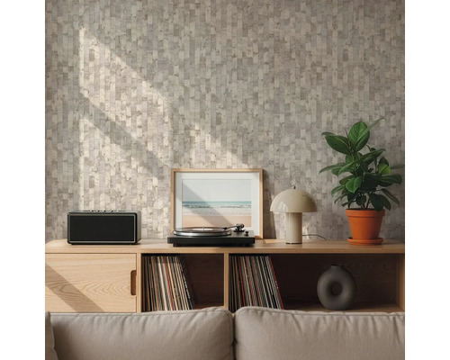 Mur avec papier peint à motif géométrique beige et gris derrière un buffet en bois avec tourne-disque et plante dans un salon lumineux.