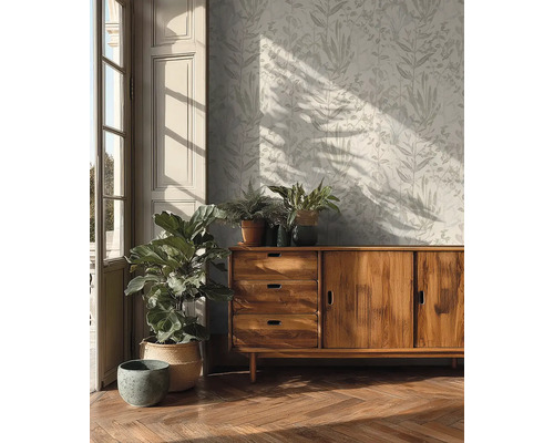 Wohnzimmer mit gemusterter Tapete, Holzkommode und Zimmerpflanzen.