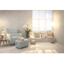 Salon lumineux avec fauteuil, repose-pied et grande fenêtre