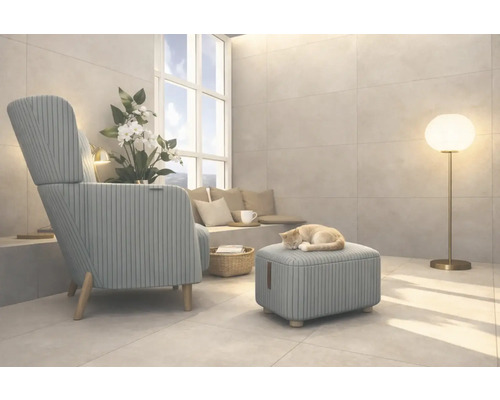 Salon avec fauteuil, tabouret, lampadaire et un chat dormant sur le tabouret