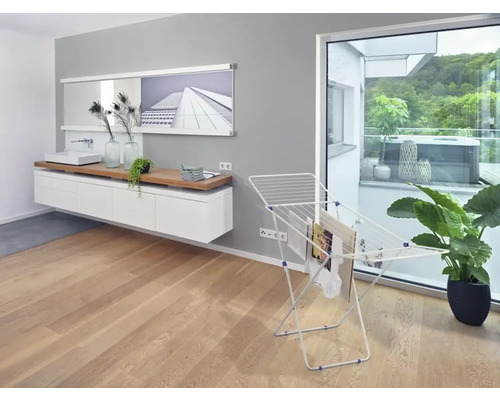 Heller Raum mit Wäscheständer, Waschtisch und Fenster zum Balkon