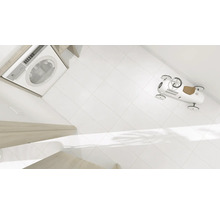 Machine à laver, carrelage blanc et voiture jouet dans la salle de bain