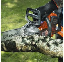 Une tronçonneuse Husqvarna coupe une branche.