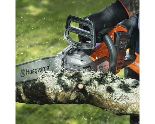 Une tronçonneuse Husqvarna coupe une branche.