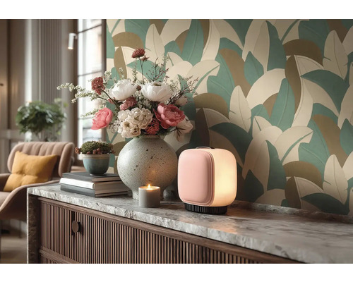 Modernes Zimmer mit großflächiger Blatttapete. Auf einem Sideboard mit Marmorplatte stehen eine Tischlampe, eine Vase mit Blumen und Dekoration.