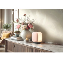 Moderne Tischleuchte auf einem Sideboard mit Marmorplatte neben einer Blumenvase und einer Kerze in einem hellen, organisierten Wohnzimmer.