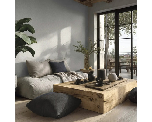 Modernes Wohnzimmer mit hellgrauer Wandfarbe, massivem Holztisch, Bodenkissen und großer Fensterfront zum Balkon.