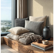Alcôve de fenêtre moderne et lumineuse avec banc en bois, divers coussins en tissu, couverture, vase et tasses à café sur un plateau.