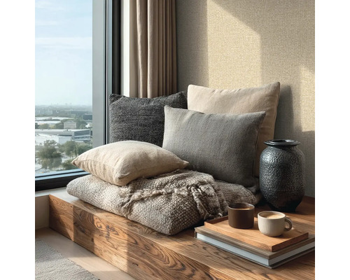 Alcôve de fenêtre moderne et lumineuse avec banc en bois, divers coussins en tissu, couverture, vase et tasses à café sur un plateau.