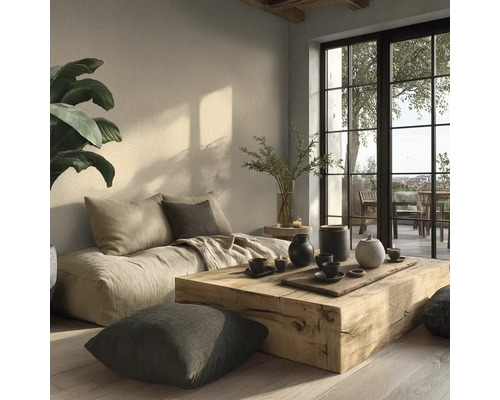 Salon minimaliste lumineux avec un canapé bas en tissu, une table basse en bloc de bois massif et de grandes fenêtres donnant sur une terrasse.