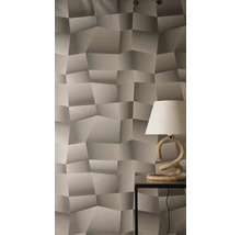 Papier peint à motif géométrique tridimensionnel et surface texturée, avec une lampe de table à pied en corde sur une table d'appoint.