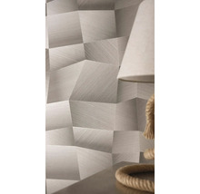 Papier peint à motif géométrique, effet 3D et structure de lignes fines dans une pièce lumineuse à côté d'une lampe.