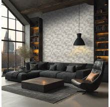 Salon moderne avec papier peint à effet 3D, canapé d'angle sombre, fauteuil en cuir et table basse en bois devant de grandes fenêtres.