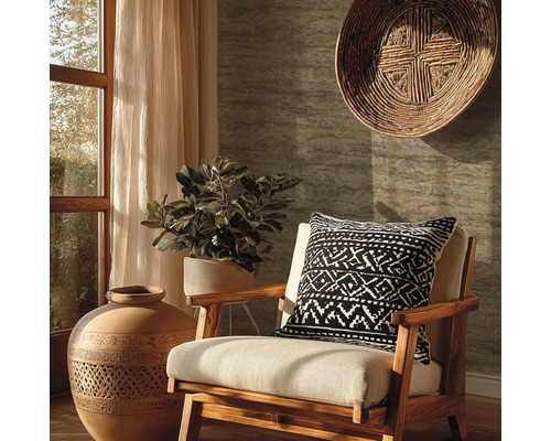 Salon avec fauteuil en bois, coussin à motifs, plante en pot, vase décorative et panier mural