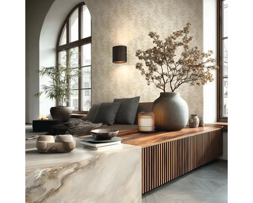 Hell gestaltetes Wohnzimmer mit Mustertapete, Wandlampe, Holz-Sideboard mit Lamellen und großer Steinvase mit Trockenzweigen.