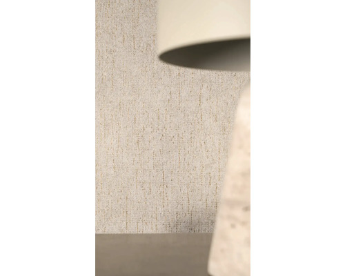 Strukturierte Vliestapete mit vertikalem Muster und Glitzereffekt hinter einer Lampe.