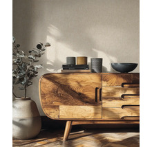 Modernes Sideboard aus Massivholz mit markanter Maserung, abgerundeten Ecken und Schubladen. Dekoriert mit Keramikgefäßen vor strukturierter Tapete.
