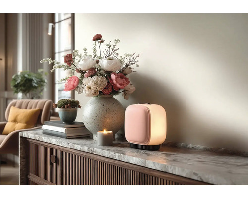 Moderne tragbare LED-Leuchte, Steinvase mit Blumen und eine Kerze auf einem Sideboard mit Marmorplatte in einem hellen Wohnraum.