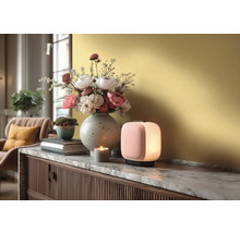 Moderne Tischleuchte auf einem Sideboard mit Marmorplatte, daneben eine Blumenvase, ein kleiner Pflanztopf und eine brennende Kerze.