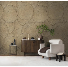 Wohnzimmer mit dekorativer Wandtapete im Kreisdesign, Sessel und Holzkommode.