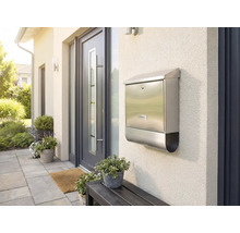 Boîte aux lettres en acier inoxydable sur un mur de maison à côté d'une porte d'entrée