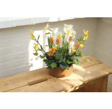 Dekorative Blumengesteck mit Narzissen in Keramiktopf auf Holztisch