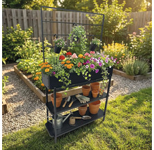 Gartenregal mit Pflanzkasten, Ablageflächen und Rankgitter mit bunten Blumen und Gartenzubehör im Garten