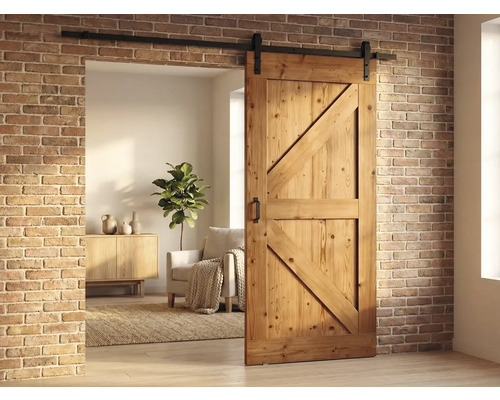 Holzschiebetür im Scheunenstil mit schwarzer Laufschiene vor einer Ziegelwand