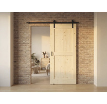 Porte coulissante en bois devant un mur en briques, partiellement ouverte et avec rail noir