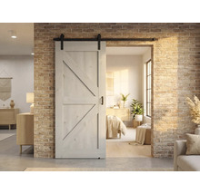 Porte coulissante en bois avec ferrures devant un mur de briques