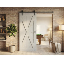 Porte coulissante en bois de style grange avec ferrures devant un mur de briques