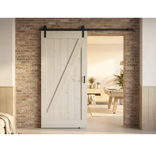 Porte coulissante en bois de style campagnard avec ferrures devant un mur de briques