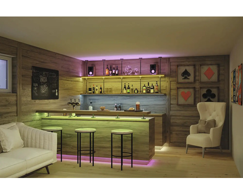 Bar à domicile moderne avec panneaux en bois, comptoir éclairé, tabourets de bar, canapé et fauteuil dans une pièce chaleureuse et organisée.