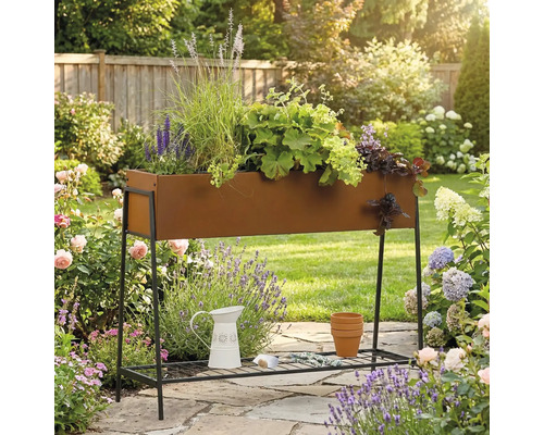 Jardinière surélevée en métal avec plantes dans le jardin.