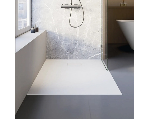 Begehbare Dusche mit flacher Duschwanne und Armatur vor Marmorwand