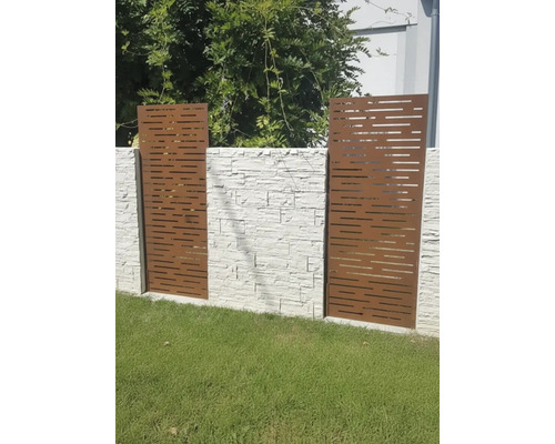 Éléments décoratifs de protection visuelle en métal avec découpes horizontales devant un mur de pierre