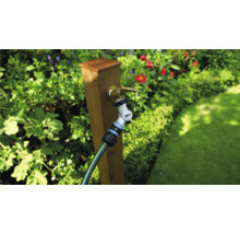 Gartenszene mit Wasserhahn, Gartenschlauch und Verbinder