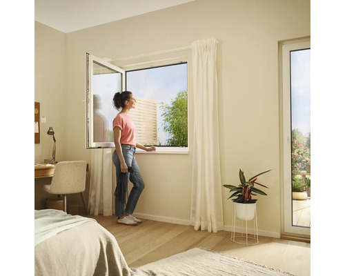 Chambre lumineuse avec fenêtre oscillo-battante et une femme regardant dehors