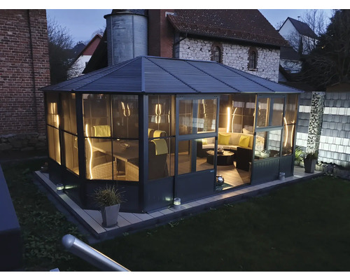 Vue extérieure d'un pavillon de jardin avec mobilier dans un jardin.