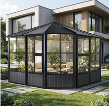 Tente de jardin avec parois en verre et coin salon dans le jardin