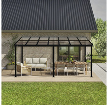 Freistehende Terrassenüberdachung mit Möbeln auf einer Holzterrasse vor einem Haus.