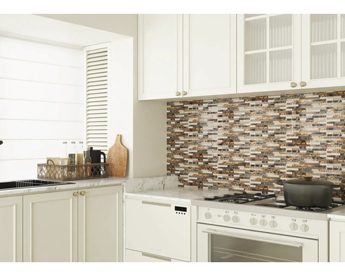 Cuisine lumineuse avec mosaïque, armoires blanches et appareils électroménagers.