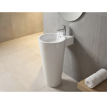 Lavabo sur pied avec robinet et serviette dans la salle de bain