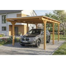 Voiture sous un abri de voiture en bois dans une cour pavée devant une maison.